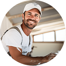 A maintenance worker wearing a white shirt and hat on a ladder