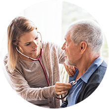 A caregiver checking the pulse of an elderly gentleman