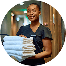 A housekeeping in the hallway holding white towels