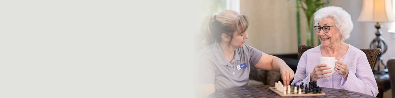 An elderly woman smiling at a caretaker